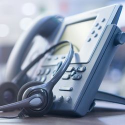 A photo of a headset and a telephone from a call center or helpline.