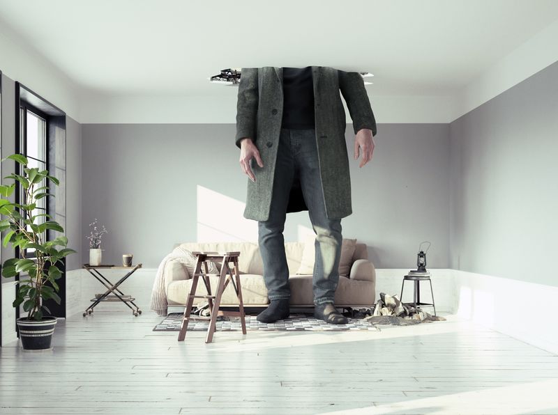 Giant human standing in living room with head through the ceiling