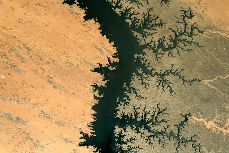 Differences in the amount of sand cover explains the starkly contrasting colors of the Egyptian lake’s west and east banks.