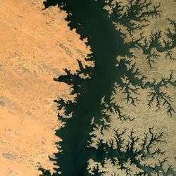 Differences in the amount of sand cover explains the starkly contrasting colors of the Egyptian lake’s west and east banks.