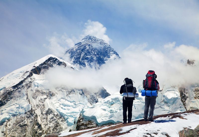 Panoramic view of Mount Everest from Kala Patthar with two tourists on the way to Everest base camp, Sagarmatha national park, Khumbu valley - Nepal