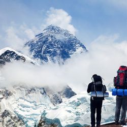 Panoramic view of Mount Everest from Kala Patthar with two tourists on the way to Everest base camp, Sagarmatha national park, Khumbu valley - Nepal