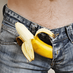 A banana poking out of a man's jean fly. 