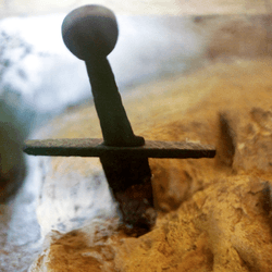 A sword hilt, protruding from the stone.